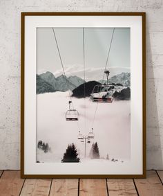 a framed photograph of a ski lift above the clouds