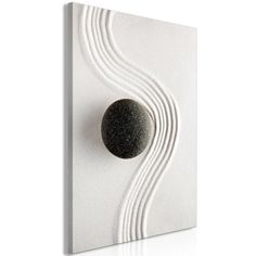 a white wall with a black ball on it's side and waves in the background