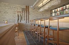 a row of bar stools in front of a brick wall