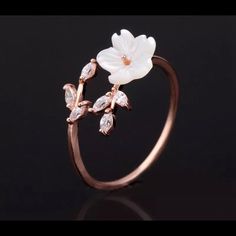 a white flower and leaves ring on a black background