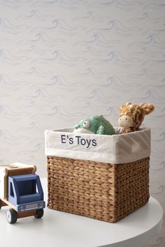 a toy truck is next to a basket with toys in it on a white table