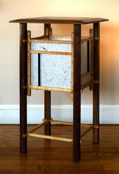 a wooden table with an ice chest on it's side and a lamp next to it