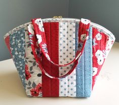 a red, white and blue bag sitting on top of a table next to a wall