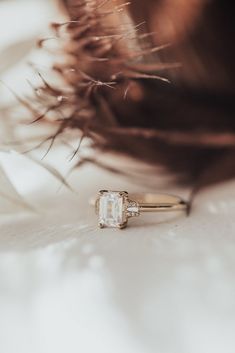 a close up of a diamond ring on top of a woman's head with her hair blowing in the wind