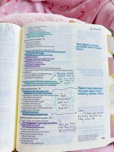 an open book with writing on it sitting on top of a pink blanket next to a stuffed animal