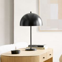 a black lamp sitting on top of a wooden table