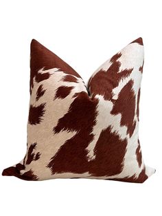 a brown and white cow print pillow on a white background