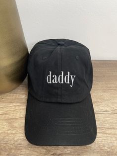 daddy dad hat, with white embroidered font. 100% cotton, adjustable fit. One size fits most. Black Cotton Dad Hat With Letter Print, Trendy Letter Embroidery Dad Hat, Dad Hat With Letter Embroidery For Streetwear, Black Dad Hat With Letter Embroidery For Streetwear, Casual Dad Hat With Letter Embroidery For Streetwear, One Size Fits Most Dad Hat For Father's Day, Streetwear Dad Hat With Letter Embroidery And Curved Bill, Trendy Dad Hat With Letter Embroidery, Trendy Dad Hat With Letter Embroidery And Curved Bill