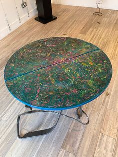 a round table with colorful paint splattered on it in a living room area