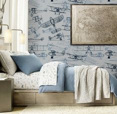 an airplane themed bedroom with blue bedding and wallpaper in shades of gray, white and beige