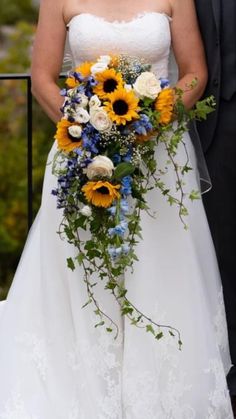 the bride and groom are posing for a photo with sunflowers on their wedding day