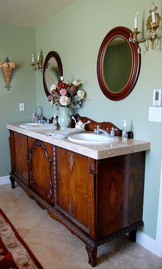 an old fashioned bathroom with two sinks and mirrors