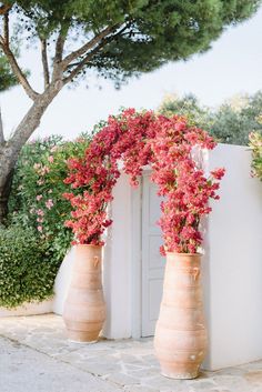 two large vases with flowers in them