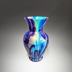 a blue and purple vase sitting on top of a table