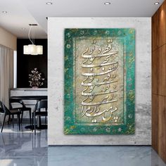 an arabic calligraphy on a green and gold background in a modern dining room with black chairs