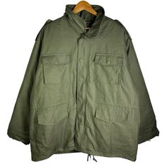 This Rothco M-65 Military Field Jacket Is A Versatile Piece Perfect For Any Occasion. Made Of A Cotton Blend Fabric With A Polyester Lining, This Jacket Is Both Heavyweight And Comfortable. It Features A Full Zip Closure With Button And Loop Accents, Along With Zipped Pockets And A Collared Neckline. The Jacket Is Lined With Removable Lining And Insulated With Polyester, Making It Perfect For Winter, Fall, And Spring Seasons. The Olive Green Color Adds A Touch Of Nature And Military Style, While Military Winter Windbreaker With Multiple Pockets, Tactical Long Sleeve Solid Outerwear, Combat Style Khaki Outerwear For Outdoor Activities, Khaki Combat Outerwear For Outdoor Activities, Tactical Khaki Windbreaker For Fall, Solid Military Windbreaker With Pockets, Military Style Solid Windbreaker With Pockets, Military Outerwear With Multiple Pockets For Outdoor Activities, Military Style Windbreaker With Pockets