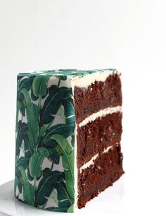 a piece of chocolate cake with banana leaves on it is cut in half to show the inside