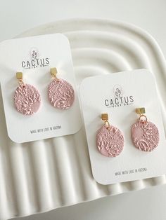 two pairs of pink and gold earrings on a white plate with the captus logo