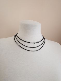 Set of 3 necklaces made of black beads. Elegant necklaces that you can present to yourself or your loved ones on special occasions. Each gothic choker necklace has a 1.5 inch adjustable chain. *First Necklace 14,17 inch / 36 cm *Second Necklace 15,94 inch / 40,5 cm *Third Necklace 18,11 inch / 46 cm   *Shipping costs for returns and exchanges belong to the buyer. *There may be some color and tone differences caused by different monitor settings. *It is not recommended to contact the jewelry with Minimalist Black Beaded Choker Necklace, Handmade Black Necklace For Layering, Black Handmade Necklace For Layering, Minimalist Black Beads For Gifts, Minimalist Black Beads For Gift, Minimalist Black Beads As Gift, Minimalist Black Beaded Necklaces As Gift, Minimalist Black Beaded Necklace For Gift, Minimalist Black Beaded Necklace As Gift