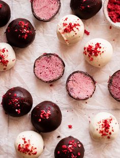 chocolate truffles with red sprinkles and white frosting on parchment paper