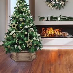 a decorated christmas tree in front of a fireplace