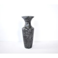 a black vase sitting on top of a white table