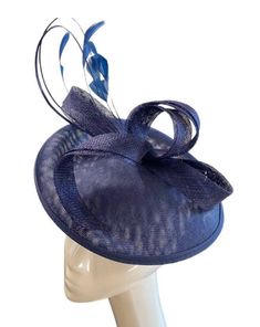 A stunning rich navy coloured sinamay flower fascinator comprised of a sinamay base, loops of sinamay in the same gorgeous navy blue colour and hand shaped feathers finished with a double quill. This fascinator sits securely on your head with a satin covered headband in a coordinating shade. A stunning addition to any outfit! Fascinator measures approx 26cm Headband measures 1cm wide Our timeless pieces are perfect for any special occasion from Weddings to The Kentucky Derby and Summer Garden Parties! We offer ready to wear pieces in a variety of styles and colour! However if you want to make your piece unique, we can customise any piece with additional feathers and make it your own! Similarly most fascinators can be created on a comb, headband or clip, whichever you would prefer! If you'r Adjustable Royal Blue Hat For Formal Occasions, Formal Blue Mini Hat With Short Brim, Fitted Blue Top Hat For Evening, Blue Adjustable Fascinator For Formal Occasions, Adjustable Blue Fascinator For Formal Occasions, Elegant Blue Fascinator For Formal Occasions, Royal Blue Adjustable Hat For Formal Occasions, Blue Curved Brim Fascinator For Formal Occasions, Blue Top Hat For Evening