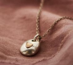 When someone you love passes away, it can be difficult to find a way to keep their spirit with you at all times. Our collection of memorial ashes jewellery enables you to keep their memory and spirit close to you always.Individually handcrafted to order in our Biggleswade studio, the beautifully organic sterling silver pebble pendant has a small chamber into which your loved one's ashes are placed.The chamber is sealed with a either a sterling silver or 9ct gold heart making a thoughtful treasur Memorial Jewelry Ashes, Pebble Pendant, Pebble Necklace, Ashes Necklace, Ashes Jewelry, Urn Necklaces, Memorial Jewelry, Stunning Necklace, Sterling Silver Heart