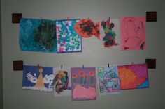 the wall is decorated with pictures and magnets for children's art work on it