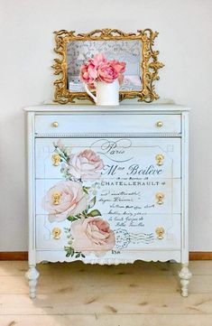 a white dresser with pink flowers on it