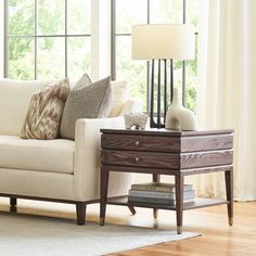 a living room scene with focus on the couch and table in front of the window