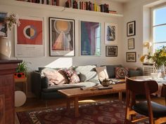 a living room filled with furniture and lots of books on the shelves above it's windows