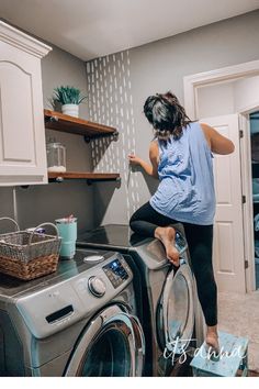 a woman standing on top of a washing machine