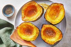 four baked delicacies on a white plate with a wooden spoon next to them