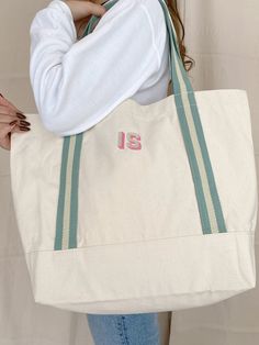 a woman holding a large white bag with the number 13 on it's side