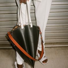 Brand New With Tags Black Leather Dual Compartment Handbag With Closure In Orange And White Strap. Comes With Dustbag. The Bag Is Crafted In Structured Smooth Calf Leather And Defined By Its Graphic Silhouette, Which Looks Like A Trapezoid From The Side. Gusset Details. Silver-Tone Metal Studs At The Base. Features A Contrasting Adjustable Shoulder Strap And Short Top Handles With Contrast Topstitching. Signature Dual-Toned Logo Stamp In Silver And Gold Tones. Open Top With Self-Tie Closure. Con Designer Shoulder Bag With Leather Lining For Shopping, Designer Shopping Bags With Leather Lining, Designer Leather Bucket Bag For Shopping, Unique Bags Design, Funky Handbags, Graphic Silhouette, Proenza Schouler Bag, Contrast Topstitching, Shoe Design