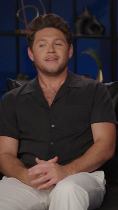 a man sitting on top of a couch in front of a tv screen with his eyes closed