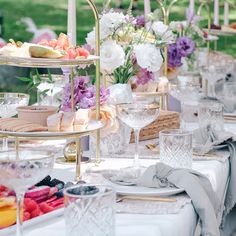 a table set up with plates, glasses and desserts