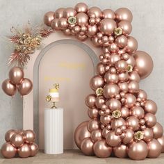 an arch made out of balloons and gold decorations