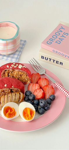 a pink plate topped with fruit and eggs