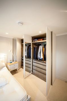 a bedroom with a bed, dresser and closets in it's center area