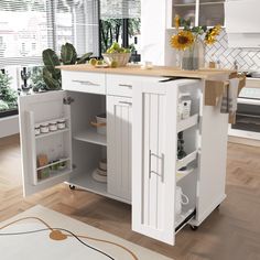 a white kitchen with sunflowers in vases on the counter and an island