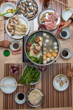 an overhead view of food being prepared on a table with chopsticks and plates