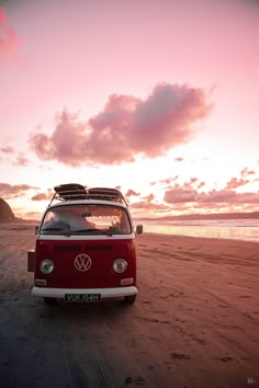 a vw bus parked on the beach at sunset