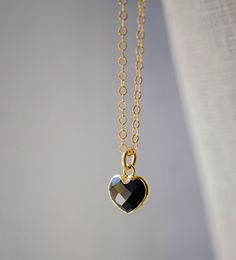 "Crafted onto a 14k gold filled chain and set in 24k gold electroplate, this black onyx heart is as precious as the affection it symbolizes. Make it that perfect gift for someone special, including yourself! Exuding protective and calming energies, Black Onyx is associated with the root chakra. It's believed to be an \"anti-panic\" stone which soothes stress and helps clear mental confusion and hyperactivity. GEMSTONE: Black Onyx STONE SIZE: average 10mm (.39\")  STONE SHAPE: Faceted Heart (Hear Black Heart-shaped Jewelry For Anniversary, Black Necklaces For Anniversary On Valentine's Day, Black Necklace For Anniversary On Valentine's Day, Valentine's Day Black Necklace For Anniversary, Black Gold-plated Adjustable Chain Jewelry, Black Faceted Jewelry As A Gift, Black Faceted Jewelry For Gift, Gold Onyx Jewelry For Anniversary, Gold Onyx Jewelry For Anniversaries