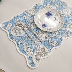 a blue and white place setting on a table