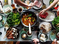 people are preparing food at a table with chopsticks and utensils on it