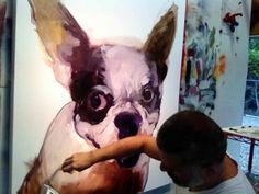 a man is painting a dog on a canvas