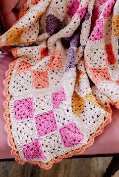 a crocheted blanket sitting on top of a pink chair