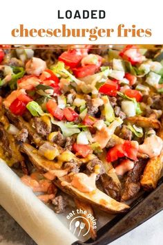 loaded cheeseburger fries on a baking sheet with text overlay that reads loaded cheeseburger fries